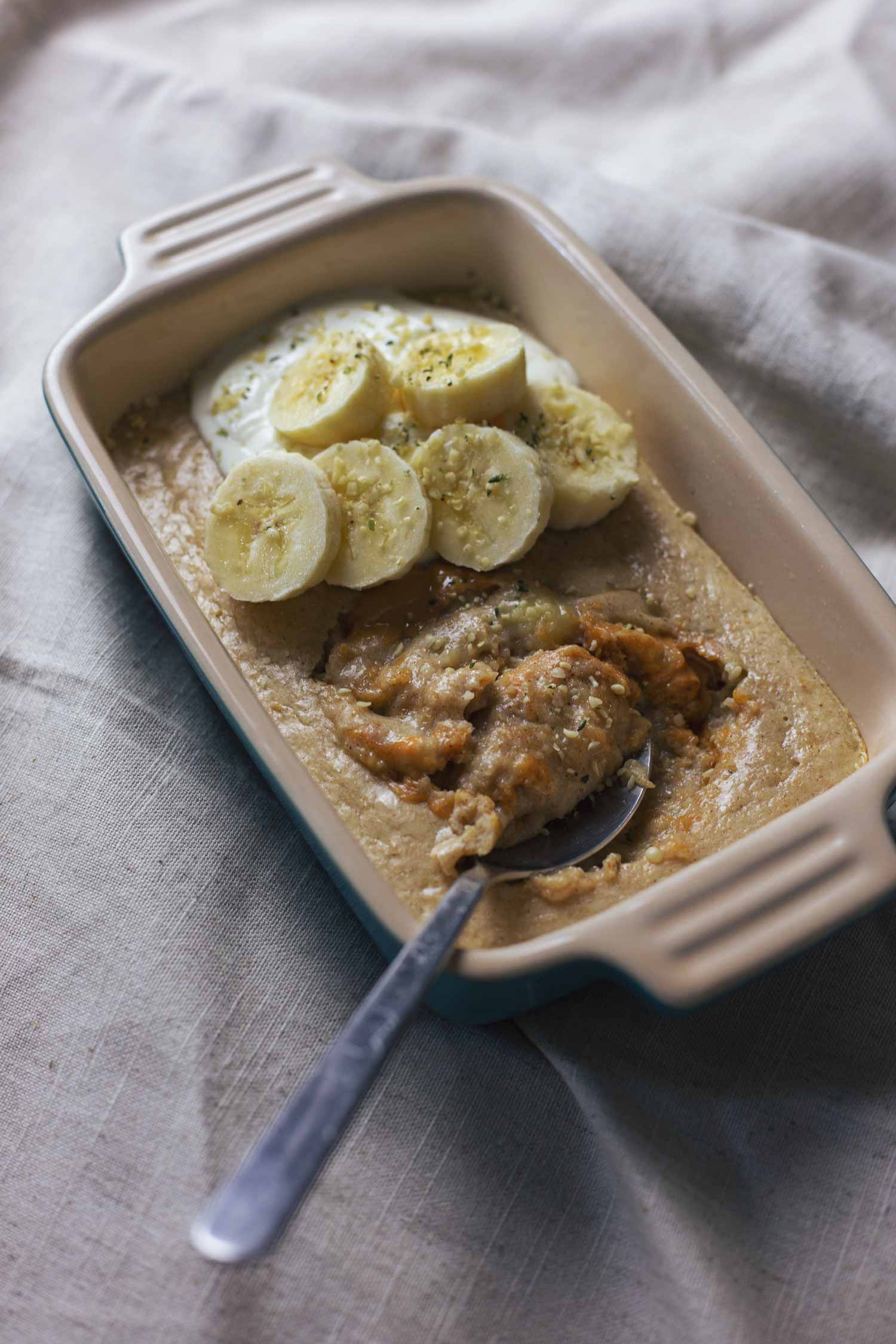 A dish of baked oats with peanut butter, banana, and greek yoghurt